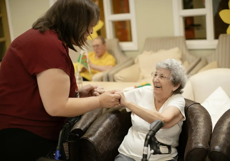 A caregiver helping an elderly woman